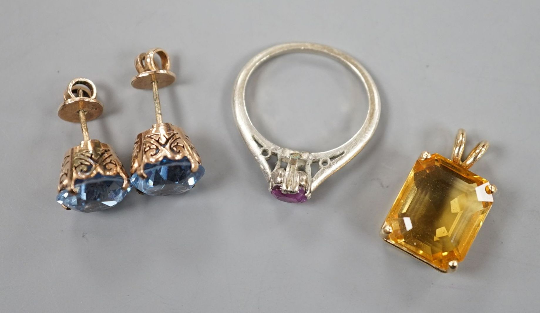 A yellow metal and citrine set pendant, overall 20mm and three other items including a pair of ear studs.